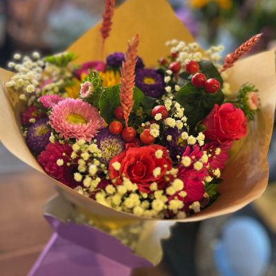 Petal Paradise - A lively bouquet featuring a bright mix of vibrant seasonal blooms. Complemented by lush green foliage and presented in a beautiful packaging, this arrangement is perfect for adding a pop of colour to any occasion